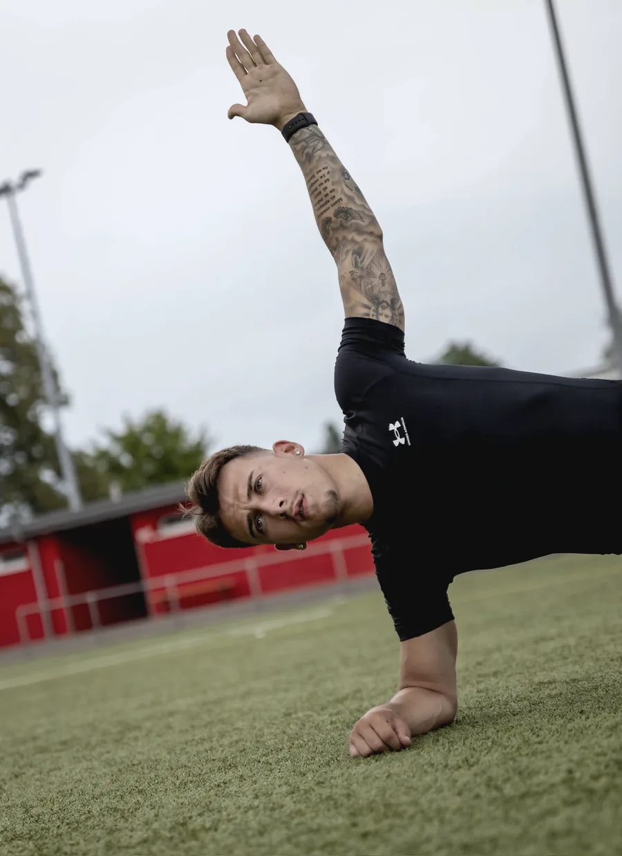 Rubén Pousa im Side Plank auf dem Sportplatz